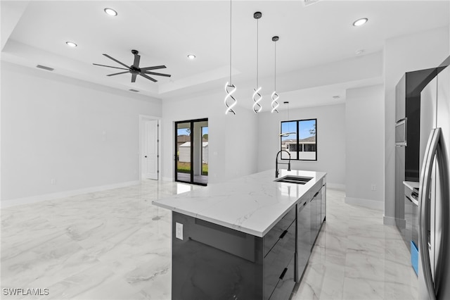 kitchen featuring recessed lighting, a sink, an island with sink, and modern cabinets
