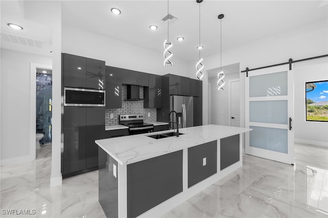 kitchen featuring visible vents, modern cabinets, dark cabinets, a sink, and appliances with stainless steel finishes