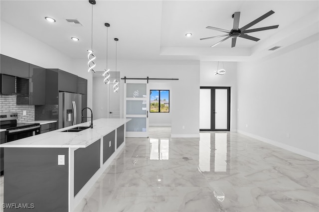 kitchen featuring visible vents, modern cabinets, a barn door, a sink, and appliances with stainless steel finishes