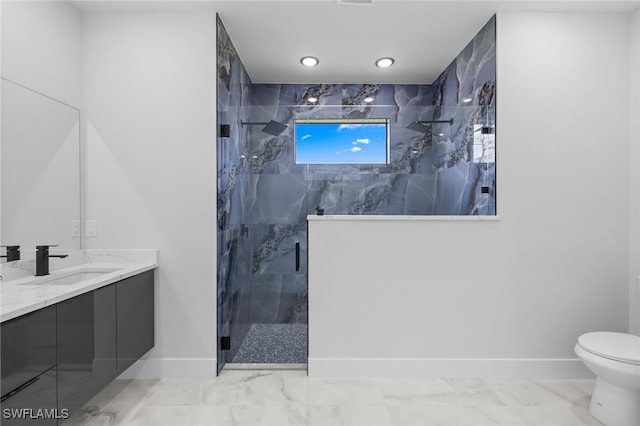 full bath with baseboards, marble finish floor, a marble finish shower, and vanity