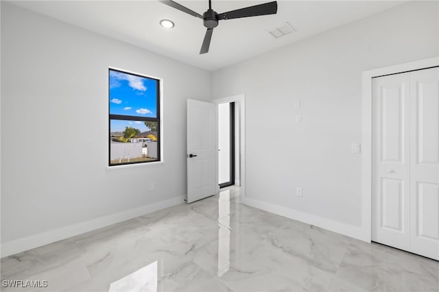 unfurnished bedroom featuring ceiling fan, marble finish floor, recessed lighting, baseboards, and a closet
