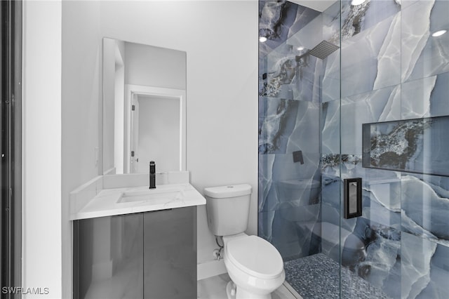 full bath with a marble finish shower, baseboards, vanity, and toilet