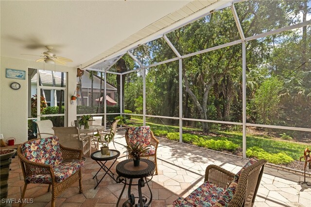 sunroom with outdoor dining area and ceiling fan