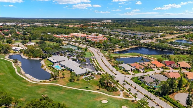 drone / aerial view featuring a water view, view of golf course, and a residential view