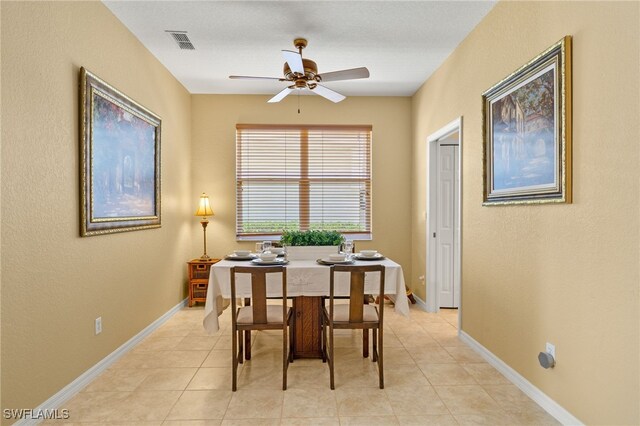 dining room featuring visible vents, a ceiling fan, baseboards, and light tile patterned flooring