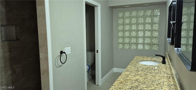 315 Cleveland Ave, Lehigh Acres, FL 33936 - bathroom with baseboards, wood finished floors, toilet, and vanity