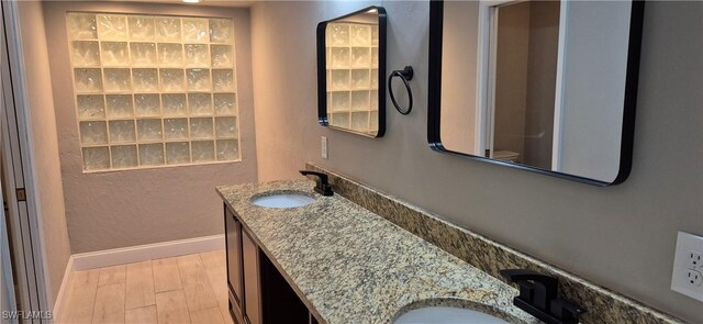 315 Cleveland Ave, Lehigh Acres, FL 33936 - full bath featuring a sink, baseboards, double vanity, and wood finished floors