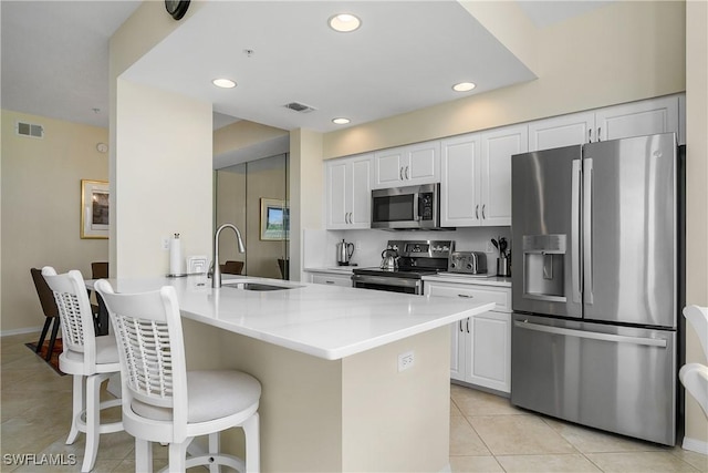 7505 Stoneybrook Dr Unit 746, Naples, FL 34112 - kitchen with a breakfast bar area, visible vents, appliances with stainless steel finishes, a sink, and light tile patterned floors