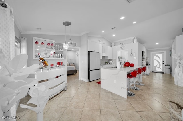 202 NE 16th Ter, Cape Coral, FL 33909 - kitchen with crown molding, freestanding refrigerator, white cabinetry, and lofted ceiling