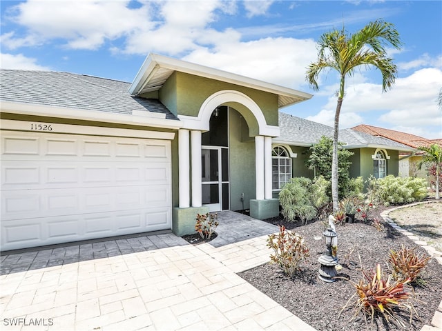 11526 Forest Mere Dr, Bonita Springs, FL 34135 - single story home with roof with shingles, an attached garage, stucco siding, and decorative driveway