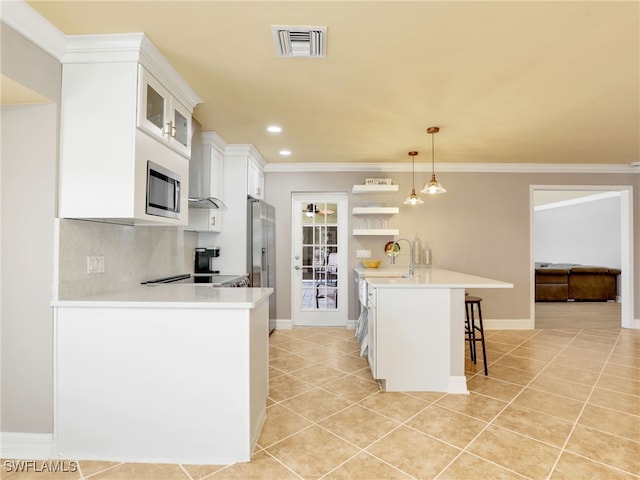 11526 Forest Mere Dr, Bonita Springs, FL 34135 - kitchen featuring a breakfast bar area, light tile patterned floors, visible vents, a peninsula, and light countertops