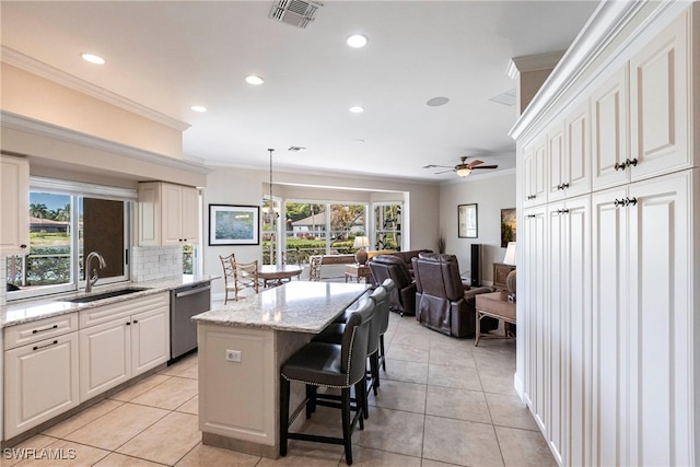 kitchen featuring a sink, crown molding, stainless steel dishwasher, and plenty of natural light