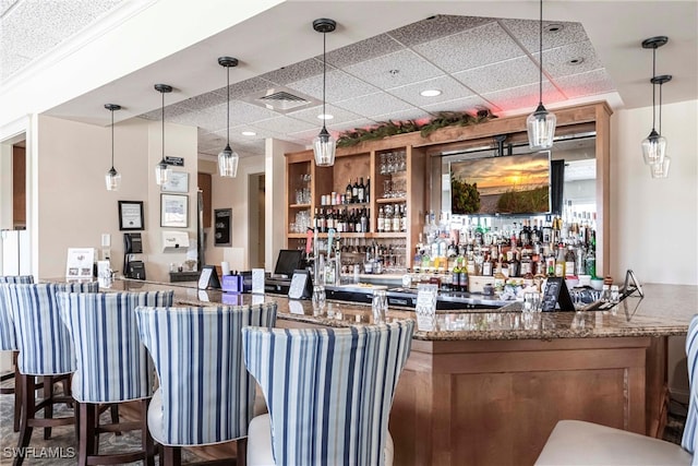 bar with a community bar, visible vents, and pendant lighting