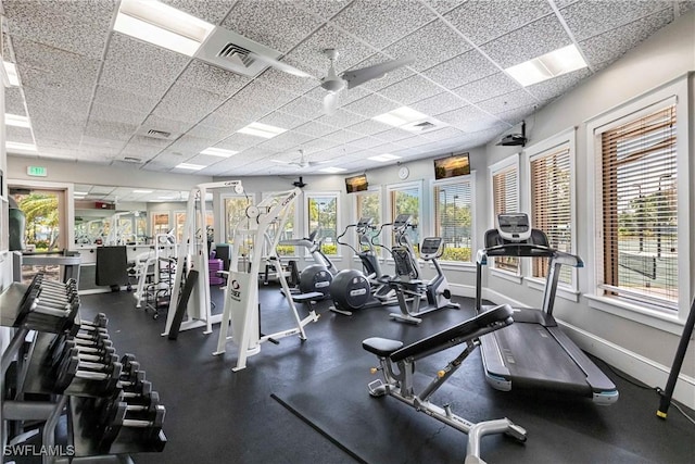 exercise room featuring a ceiling fan, baseboards, visible vents, and a paneled ceiling