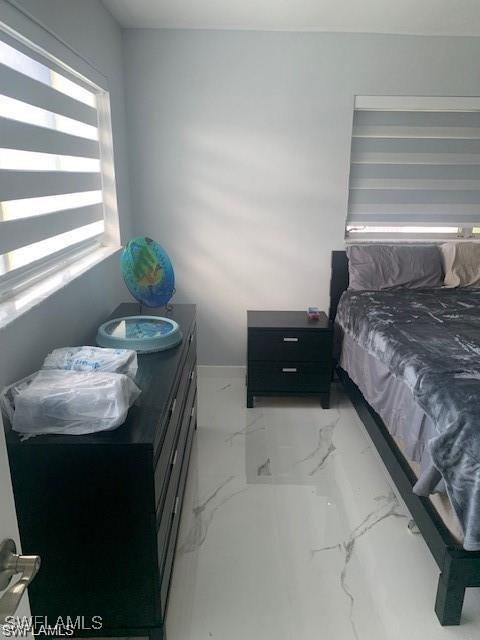 bedroom featuring marble look tile flooring