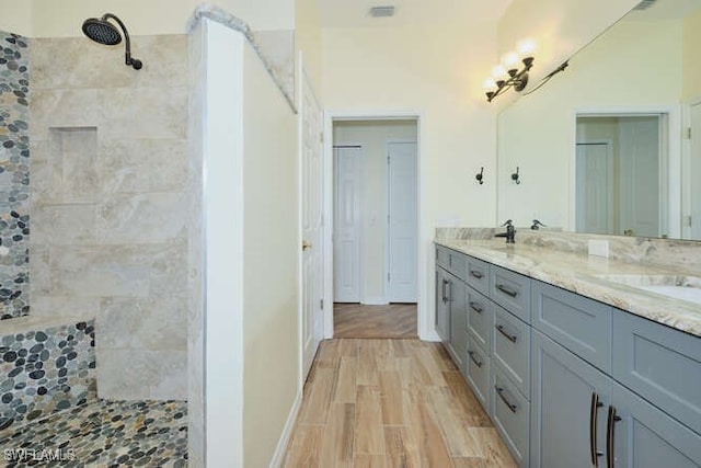 14571 Grande Cay Cir Unit 3203, Fort Myers, FL 33908 - bathroom with double vanity, a sink, a tile shower, and wood finished floors