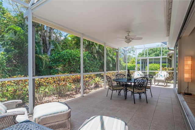 sunroom featuring a ceiling fan and outdoor dining space