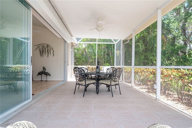 sunroom featuring ceiling fan, a wealth of natural light, and outdoor dining area
