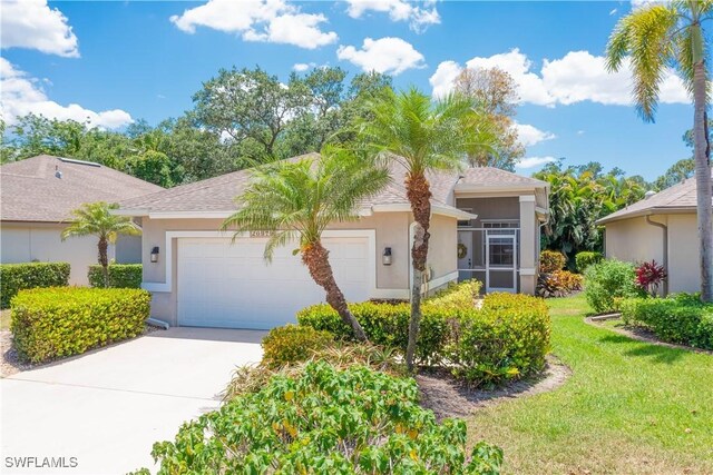ranch-style house with concrete driveway, stucco siding, a front lawn, and an attached garage