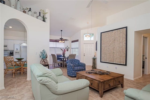 living room with a ceiling fan, light tile patterned floors, high vaulted ceiling, and arched walkways