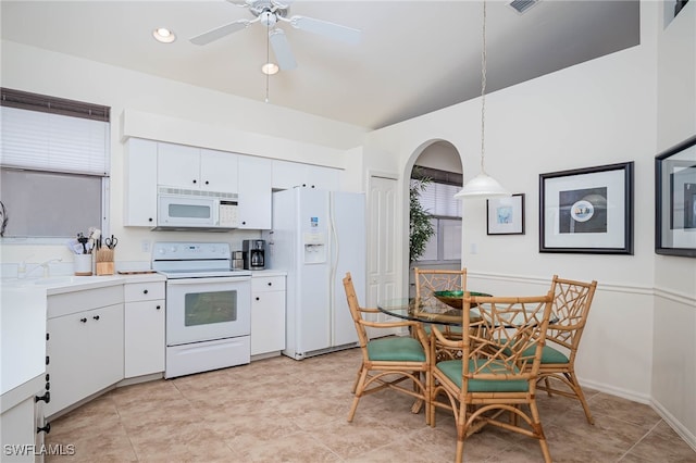 kitchen featuring white cabinets, light countertops, pendant lighting, and white appliances