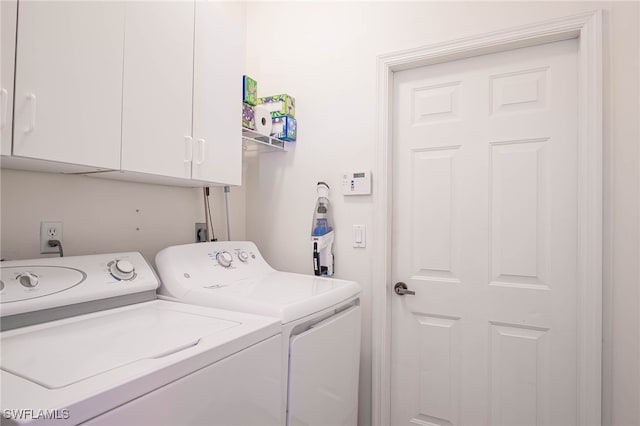 washroom featuring separate washer and dryer and cabinet space