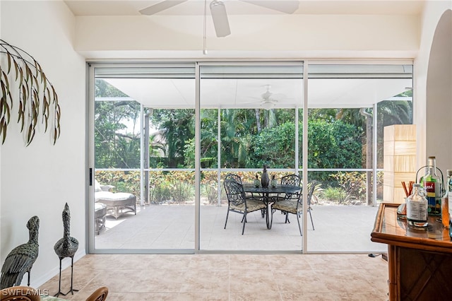 sunroom / solarium with outdoor dining area and a ceiling fan