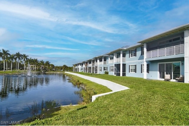view of home's community with a water view and a yard