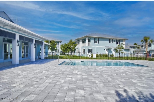 pool featuring fence, a patio area, and french doors