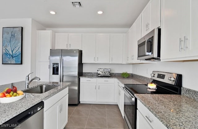 kitchen featuring white cabinets, stainless steel appliances, visible vents, and a sink