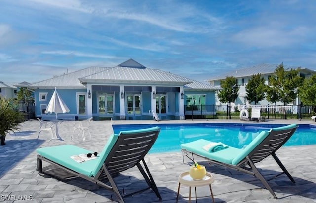 view of swimming pool featuring a patio, fence, french doors, and a fenced in pool