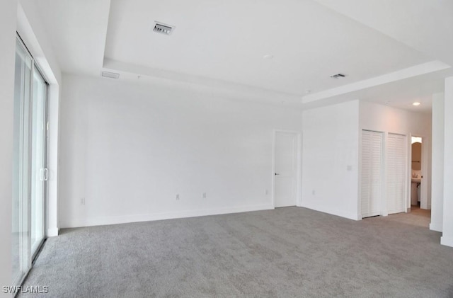 unfurnished bedroom featuring visible vents, recessed lighting, carpet floors, and a tray ceiling