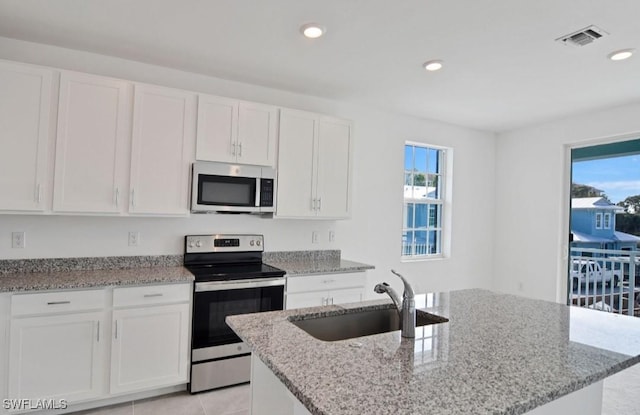 kitchen with visible vents, a sink, appliances with stainless steel finishes, and white cabinets