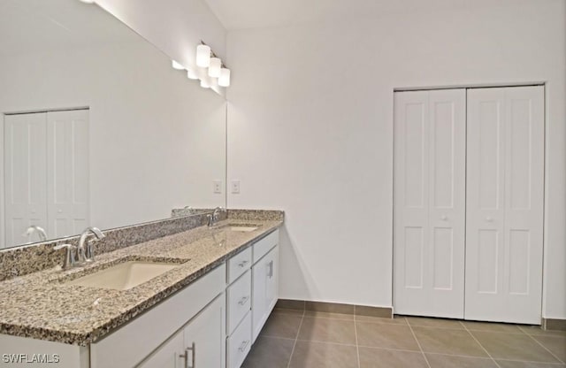 bathroom with a sink, tile patterned floors, and a closet