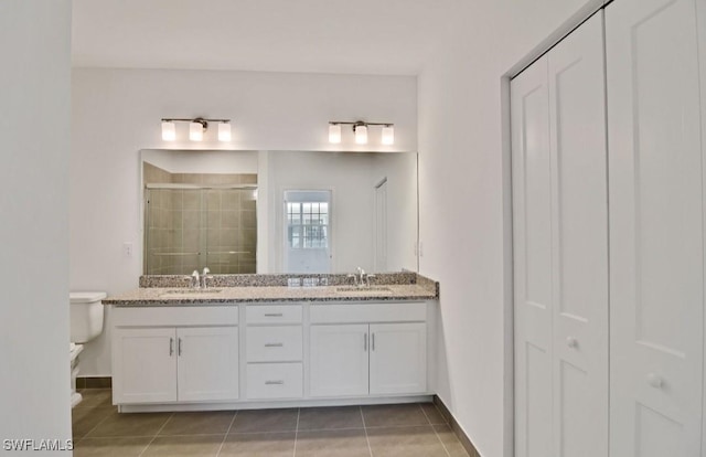 full bathroom with toilet, a sink, tile patterned flooring, and a stall shower
