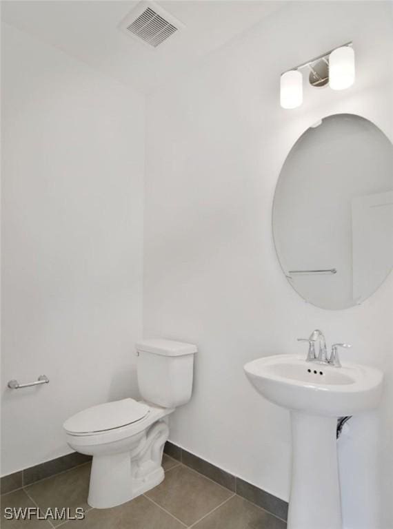 bathroom featuring toilet, tile patterned floors, visible vents, and baseboards