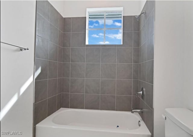 bathroom with shower / bathing tub combination and toilet