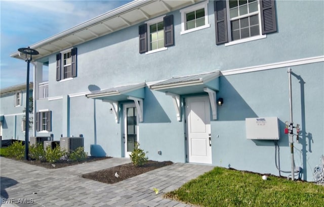 view of front of property featuring central AC unit and stucco siding