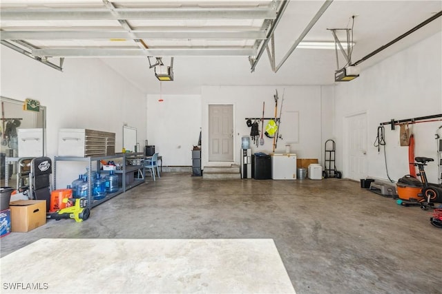 239 Leawood Cir, Naples, FL 34104 - garage featuring a garage door opener and fridge