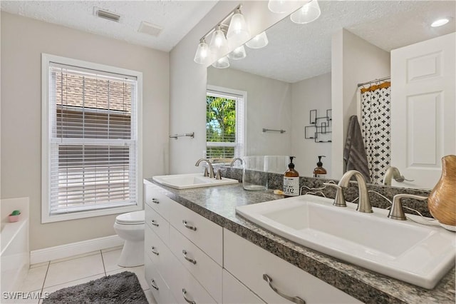 239 Leawood Cir, Naples, FL 34104 - bathroom featuring double vanity, toilet, a textured ceiling, baseboards, and tile patterned flooring