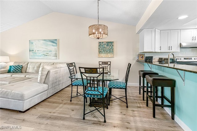 6308 Sugar Bush Ln Unit E, Fort Myers, FL 33908 - dining space with vaulted ceiling, a chandelier, light wood-style flooring, and baseboards
