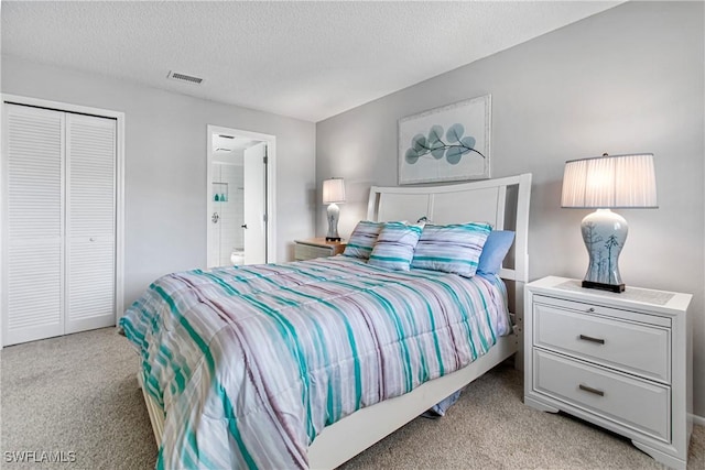 6308 Sugar Bush Ln Unit E, Fort Myers, FL 33908 - bedroom with carpet flooring, a textured ceiling, connected bathroom, and a closet