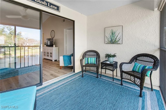 6308 Sugar Bush Ln Unit E, Fort Myers, FL 33908 - living area featuring a textured wall, wood finished floors, a ceiling fan, and baseboards
