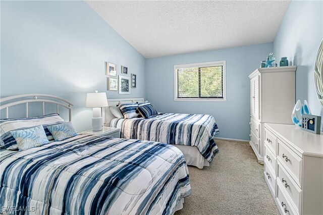 6308 Sugar Bush Ln Unit E, Fort Myers, FL 33908 - bedroom featuring light carpet, vaulted ceiling, and a textured ceiling