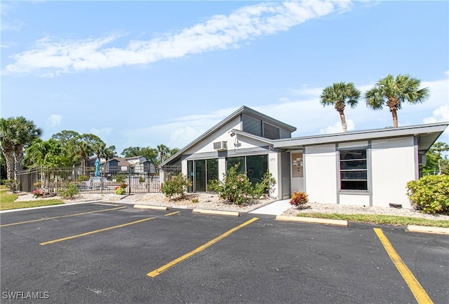 6308 Sugar Bush Ln Unit E, Fort Myers, FL 33908 - view of front of home with uncovered parking, fence, and stucco siding