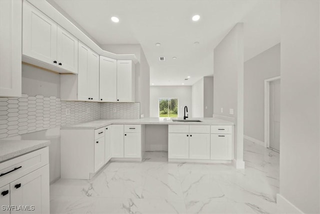836 Clow St E, Lehigh Acres, FL 33974 - kitchen with decorative backsplash, recessed lighting, light marble finish flooring, white cabinetry, and light countertops