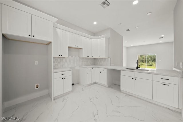836 Clow St E, Lehigh Acres, FL 33974 - kitchen with recessed lighting, light marble finish flooring, white cabinetry, decorative backsplash, and a peninsula