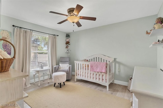 10225 Bismark Palm Way Unit 1626, Fort Myers, FL 33966 - bedroom with wood finished floors, a crib, ceiling fan, and baseboards