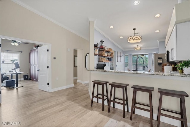 10225 Bismark Palm Way Unit 1626, Fort Myers, FL 33966 - kitchen with freestanding refrigerator, crown molding, a breakfast bar, white cabinetry, and light wood finished floors