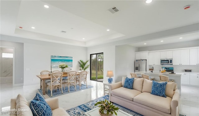 203 E 10th St, Lehigh Acres, FL 33972 - living area with light marble finish floors, recessed lighting, and a tray ceiling